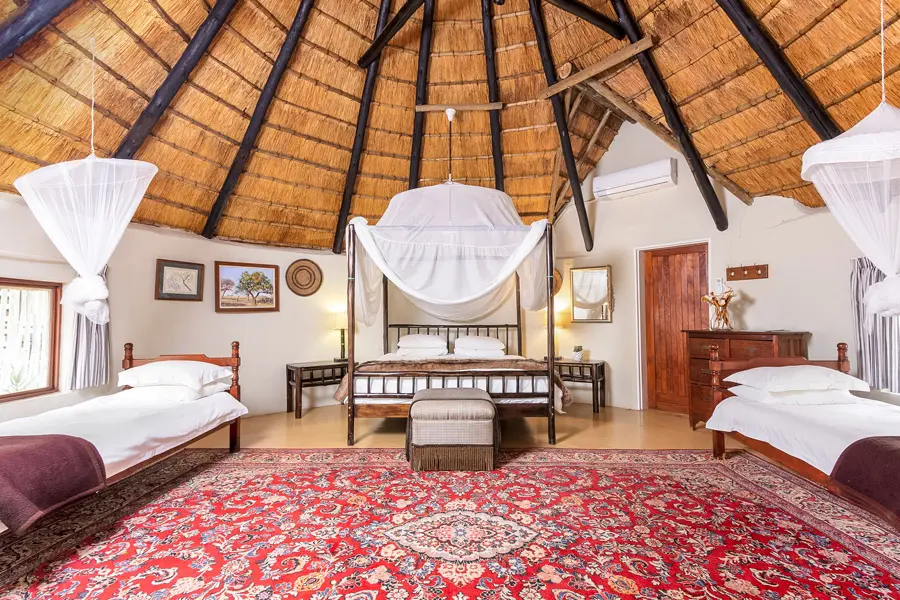Thatched family suite with mosquito-netted beds at Walkers River Camp